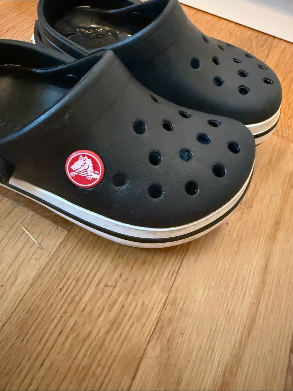 Kid’s black Croc slip on shoe with white band size 8